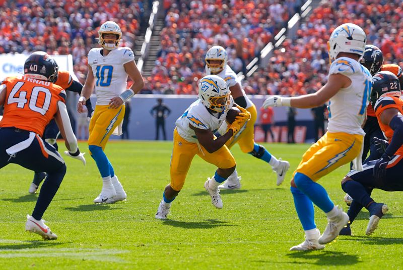 Los Angeles Chargers running back J.K. Dobbins (27) runs with the football during the first half of an NFL football game against the Denver Broncos, Sunday, Oct. 13, 2024, in Denver. (AP Photo/David Zalubowski)