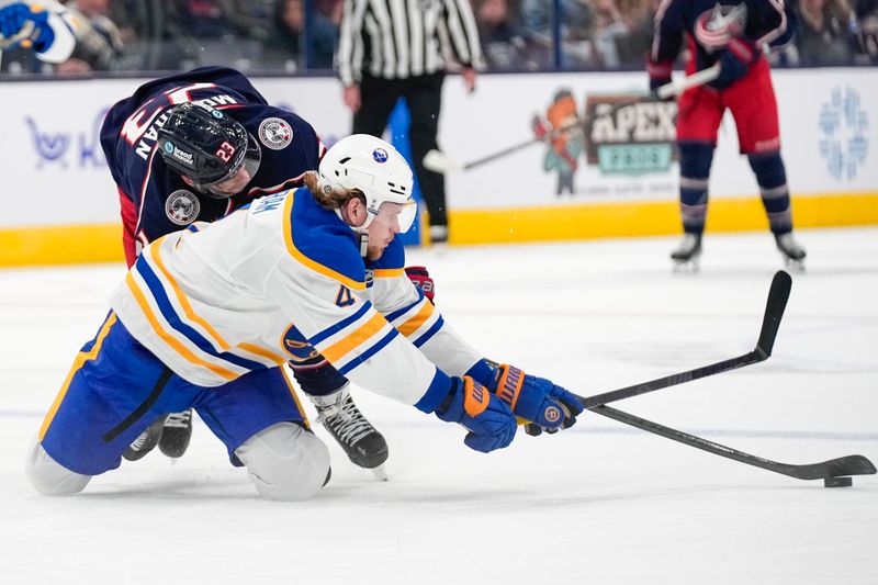 Oct 17, 2024; Columbus, Ohio, USA; Buffalo Sabres defenseman Bowen Byram (4) fights for the puck against Columbus Blue Jackets center Sean Monahan (23) in the third period at Nationwide Arena on Thursday. Mandatory Credit: Samantha Madar/USA TODAY Network via Imagn Images