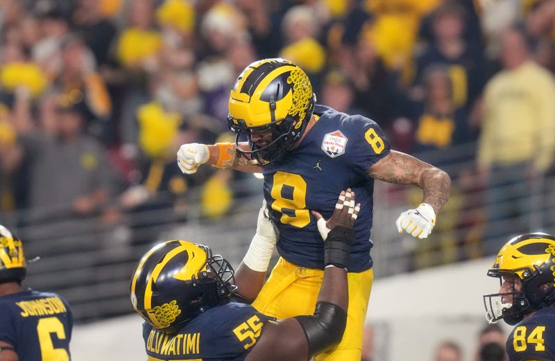 Dec 31, 2022; Glendale, Arizona, USA; Michigan Wolverines receiver Ronnie Bell (8) celebrates with teammate Olusegun Oluwatimi (55) after scoring a touchdown against the TCU Horned Frogs during the Vrbo Fiesta Bowl at State Farm Stadium. Mandatory Credit: Joe Rondone-Arizona Republic