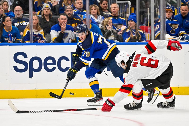 Nov 3, 2023; St. Louis, Missouri, USA;  St. Louis Blues left wing Sammy Blais (79) passes the puck past New Jersey Devils defenseman John Marino (6) during the second period at Enterprise Center. Mandatory Credit: Jeff Curry-USA TODAY Sports