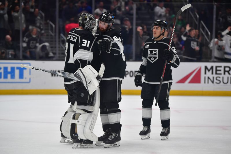 Mar 11, 2024; Los Angeles, California, USA; Los Angeles Kings goaltender David Rittich (31) defenseman Vladislav Gavrikov (84) and defenseman Jordan Spence (21) celebrate the victory against the New York Islanders at Crypto.com Arena. Mandatory Credit: Gary A. Vasquez-USA TODAY Sports