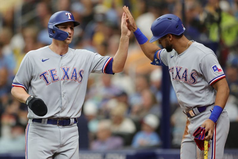 Oct 4, 2023; St. Petersburg, Florida, USA; Texas Rangers shortstop Corey Seager (5) high fives center fielder Leody Taveras (3) after scoring a run against the Tampa Bay Rays in the fifth inning during game two of the Wildcard series for the 2023 MLB playoffs at Tropicana Field. Mandatory Credit: Nathan Ray Seebeck-USA TODAY Sports