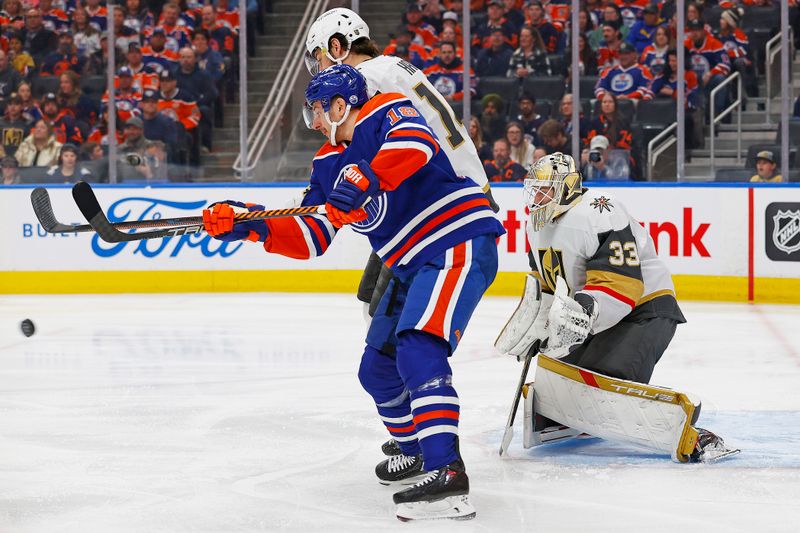 Apr 10, 2024; Edmonton, Alberta, CAN; Edmonton Oilers forward Zach Hyman (18) tries to deflect a shot on Vegas Golden Knights goaltender Adin Hill (33) during the first period at Rogers Place. Mandatory Credit: Perry Nelson-USA TODAY Sports