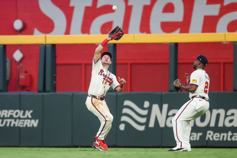 Aug 1, 2024; Atlanta, Georgia, USA; Atlanta Braves center fielder Jarred Kelenic (24) catches a fly ball as right fielder Jorge Soler (2) looks on against the Miami Marlins in the fifth inning at Truist Park. Mandatory Credit: Brett Davis-USA TODAY Sports
