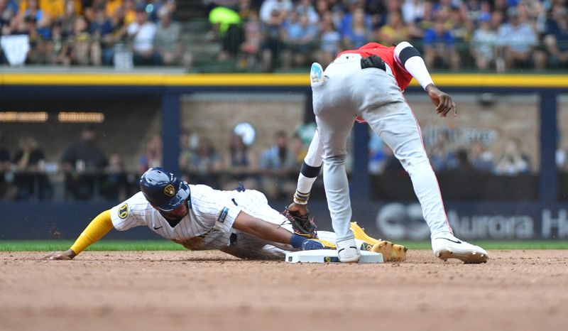 Jun 15, 2024; Milwaukee, Wisconsin, USA; Milwaukee Brewers outfielder Jackson Chourio (11) slides safely into second base ahead of the tag by Cincinnati Reds shortstop Elly De La Cruz (44) in the fifth inning at American Family Field. Mandatory Credit: Michael McLoone-USA TODAY Sports