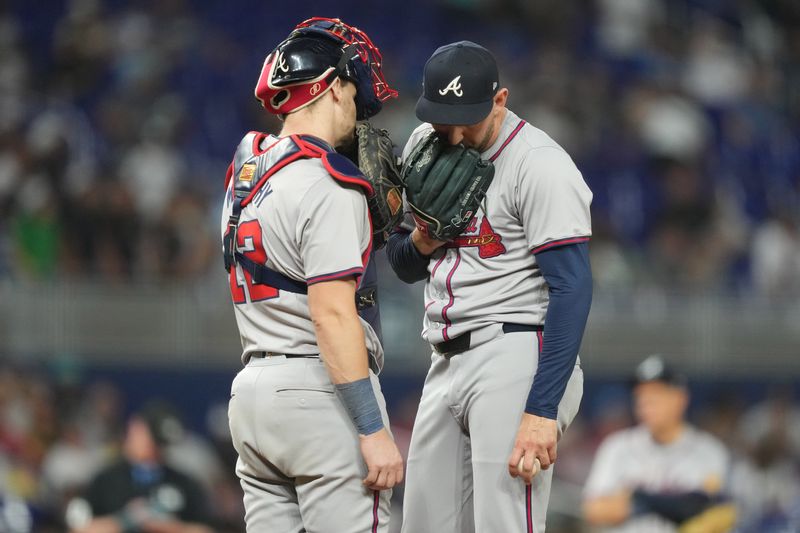 Sep 20, 2024; Miami, Florida, USA;  Atlanta Braves pitcher Dylan Lee (52) talks with catcher Sean Murphy (12) in the seventh inning against the Miami Marlins at loanDepot Park. Mandatory Credit: Jim Rassol-Imagn Images