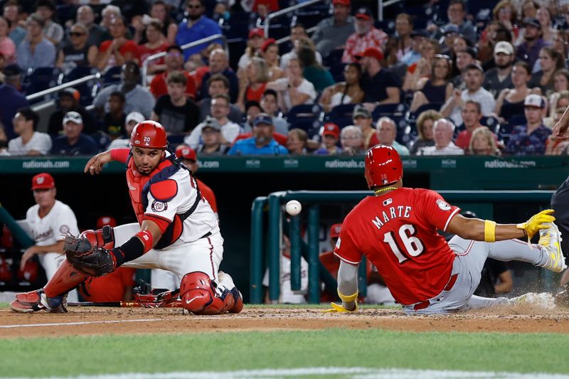 Jul 19, 2024; Washington, District of Columbia, USA; Cincinnati Reds third base Noelvi Marte (16) slides across home plate to score a run ahead of an attempted tag by Washington Nationals catcher Keibert Ruiz (20) during the ninth inning at Nationals Park. Mandatory Credit: Geoff Burke-USA TODAY Sports