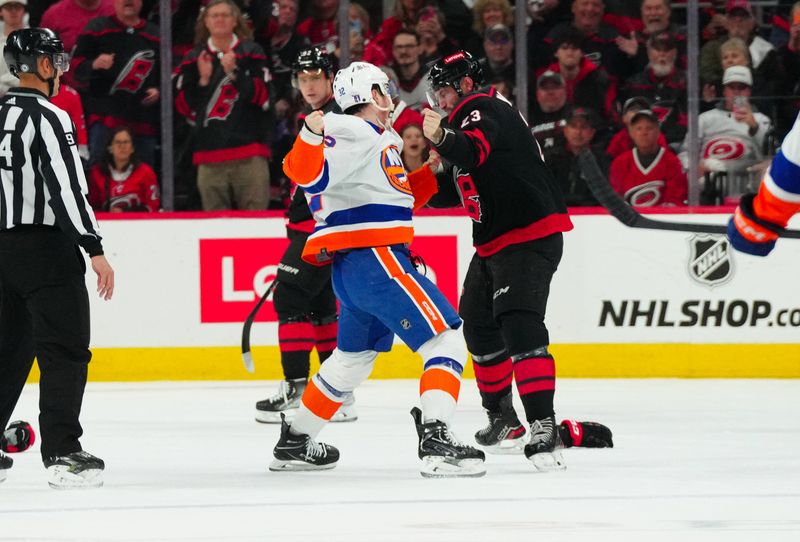 Apr 22, 2024; Raleigh, North Carolina, USA; Carolina Hurricanes right wing Stefan Noesen (23) and New York Islanders center Kyle MacLean (32) fight during the first period in game two of the first round of the 2024 Stanley Cup Playoffs at PNC Arena. Mandatory Credit: James Guillory-USA TODAY Sports