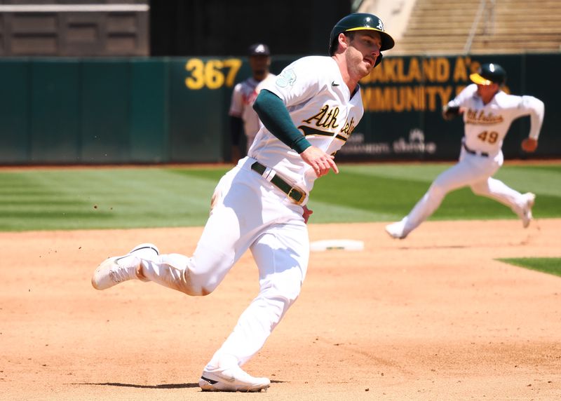 May 31, 2023; Oakland, California, USA; Oakland Athletics left fielder Brett Rooker (25) rounds third base ahead of first baseman Ryan Noda (49) to score a run against the Atlanta Braves during the sixth inning at Oakland-Alameda County Coliseum. Mandatory Credit: Kelley L Cox-USA TODAY Sports