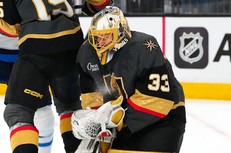 Apr 3, 2025; Las Vegas, Nevada, USA; Vegas Golden Knights goaltender Adin Hill (33) makes a save against the Winnipeg Jets during the first period at T-Mobile Arena. Mandatory Credit: Stephen R. Sylvanie-Imagn Images