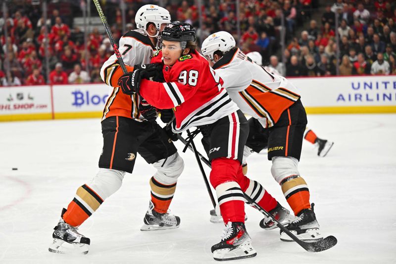 Dec 7, 2023; Chicago, Illinois, USA; Chicago Blackhawks forward Connor Bedard (98) is checked by Anaheim Ducks defenseman Radko Gudas (7) in the first period at United Center. Mandatory Credit: Jamie Sabau-USA TODAY Sports