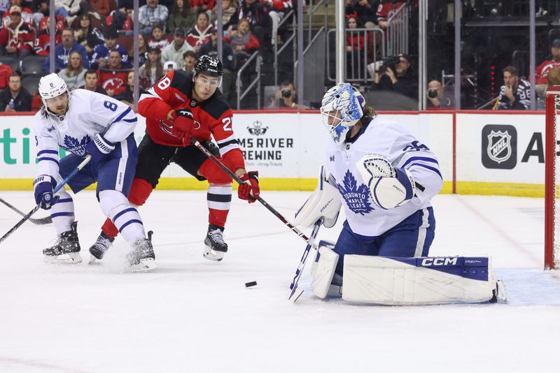 Oct 10, 2024; Newark, New Jersey, USA; Toronto Maple Leafs goaltender Dennis Hildeby (35) defends his net while New Jersey Devils right wing Timo Meier (28) reaches for the puck during the second period at Prudential Center. Mandatory Credit: Ed Mulholland-Imagn Images