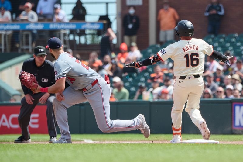 Apr 10, 2024; San Francisco, California, USA; San Francisco Giants shortstop Nick Ahmed (16) gestures a safe sign after hitting a single against  Washington Nationals first baseman Joey Gallo (24) during the fifth inning at Oracle Park. Mandatory Credit: Robert Edwards-USA TODAY Sports