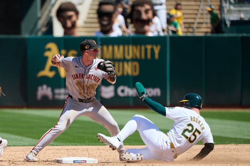 Aug 18, 2024; Oakland, California, USA; San Francisco Giants infielder Tyler Fitzgerald (49) forces out Oakland Athletics outfielder Brent Rooker (25) at second base during the sixth inning at Oakland-Alameda County Coliseum. Mandatory Credit: Robert Edwards-USA TODAY Sports