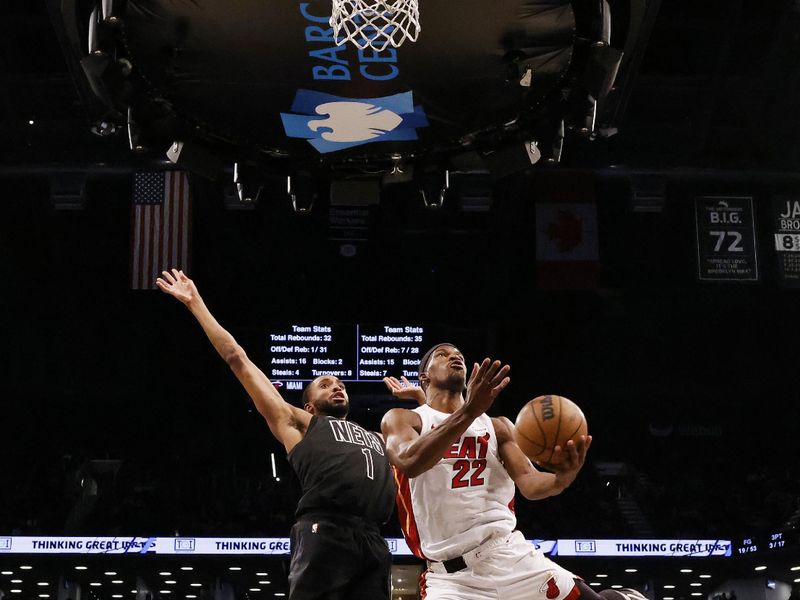 NEW YORK, NEW YORK - JANUARY 15:  Jimmy Butler #22 of the Miami Heat  shoots against Mikal Bridges #1 of the Brooklyn Nets during their game at Barclays Center on January 15, 2024 in New York City.   User expressly acknowledges and agrees that, by downloading and or using this photograph, User is consenting to the terms and conditions of the Getty Images License Agreement.  (Photo by Al Bello/Getty Images)