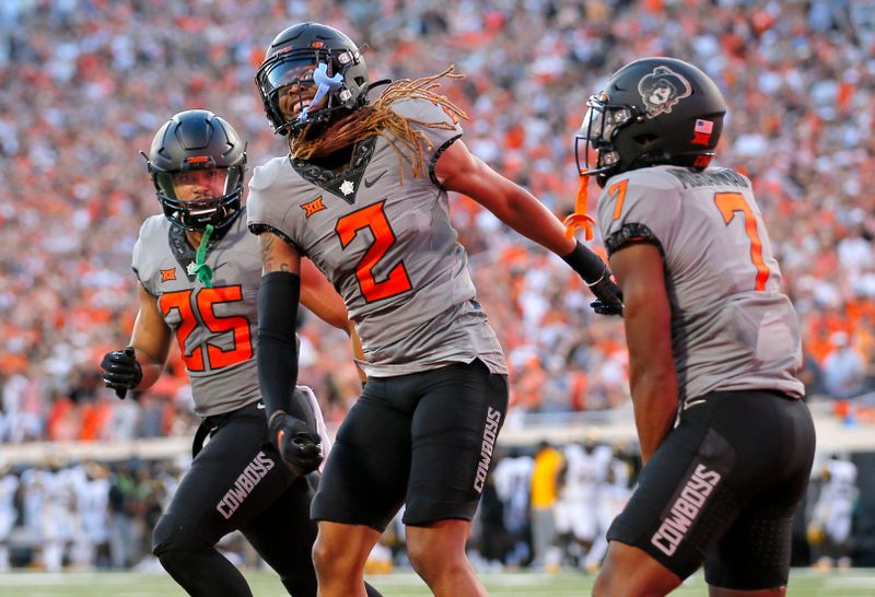 Sep 17, 2022; Stillwater, Oklahoma, USA; Oklahoma State Cowboys cornerback Korie Black (2) celebrates with safety Jason Taylor II (25) and cornerback Jabbar Muhammad (7) after scoring a touchdown on a blocked field goal against the Arkansas-Pine Bluff Golden Lions at Boone Pickens Stadium. Mandatory Credit: Sarah Phipps-USA TODAY Sports

