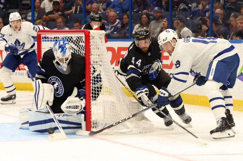 Apr 17, 2024; Tampa, Florida, USA; Toronto Maple Leafs center Noah Gregor (18) shoots on goal as Tampa Bay Lightning goaltender Matt Tomkins (90) and defenseman Calvin de Haan (44) defend during the second period at Amalie Arena. Mandatory Credit: Kim Klement Neitzel-USA TODAY Sports