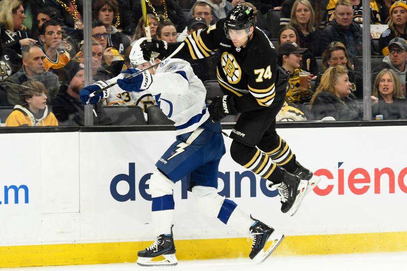 Feb 13, 2024; Boston, Massachusetts, USA;  Boston Bruins left wing Jake DeBrusk (74) leaps by Tampa Bay Lightning defenseman Haydn Fleury (7) during the first period at TD Garden. Mandatory Credit: Bob DeChiara-USA TODAY Sports