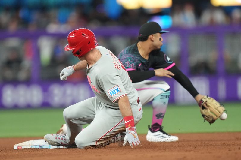 Sep 6, 2025; Miami, Florida, USA;  Philadelphia Phillies catcher J.T. Realmuto (10) slides into second base with a double in the fifth inning as Miami Marlins second baseman Maximo Acosta (24) is late with the tag. Mandatory Credit: Jim Rassol-Imagn Images