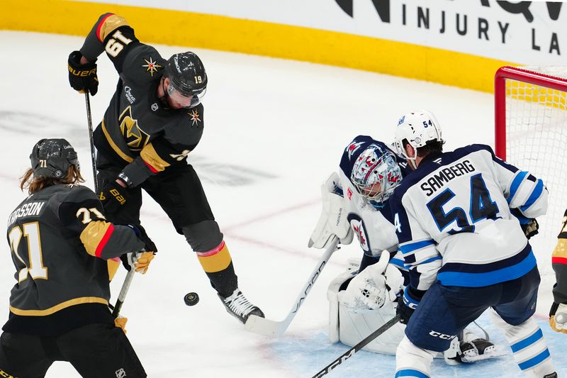 Apr 3, 2025; Las Vegas, Nevada, USA; Vegas Golden Knights right wing Reilly Smith (19) looks to deflect a rebound after Winnipeg Jets goaltender Eric Comrie (1) makes a save during the third period at T-Mobile Arena. Mandatory Credit: Stephen R. Sylvanie-Imagn Images