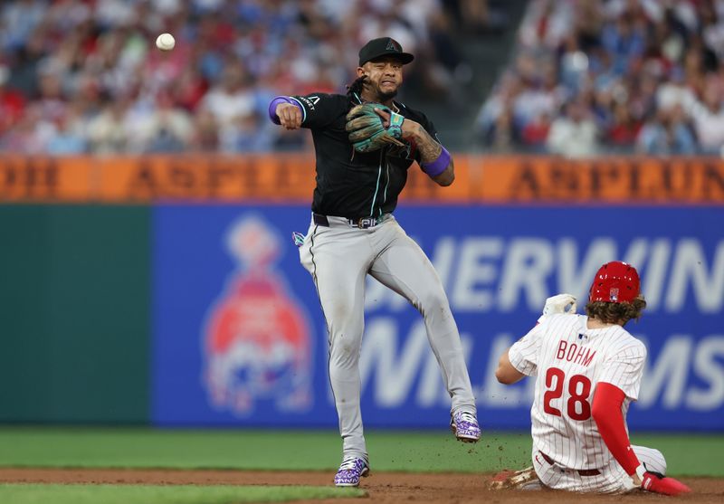 May 3, 2025; Philadelphia, Pennsylvania, USA; Arizona Diamondbacks second base Ketel Marte (4) unsuccessfully throws to first after tagging out Philadelphia Phillies third base Alec Bohm (28) during the fifth inning at Citizens Bank Park. Mandatory Credit: Bill Streicher-Imagn Images