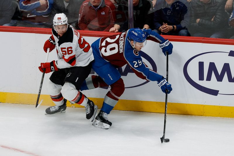 Feb 26, 2025; Denver, Colorado, USA; Colorado Avalanche center Nathan MacKinnon (29) controls the puck under pressure from New Jersey Devils left wing Erik Haula (56) in the first period at Ball Arena. Mandatory Credit: Isaiah J. Downing-Imagn Images