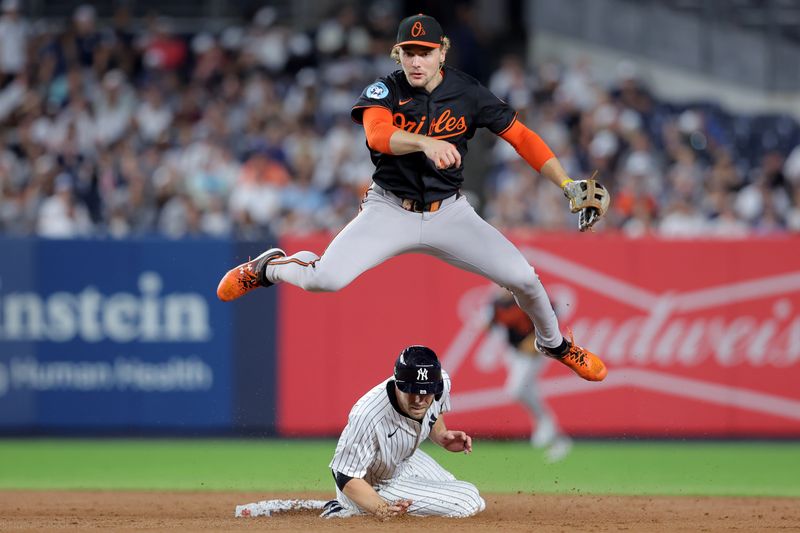 Sep 26, 2025; Bronx, New York, USA; Baltimore Orioles shortstop Gunnar Henderson (2) leaps over New York Yankees left fielder Austin Slater (29) after forcing him out and throwing to first base to complete a double play on a ball hit by Yankees catcher Austin Wells (not pictured) during the second inning at Yankee Stadium. Mandatory Credit: Brad Penner-Imagn Images