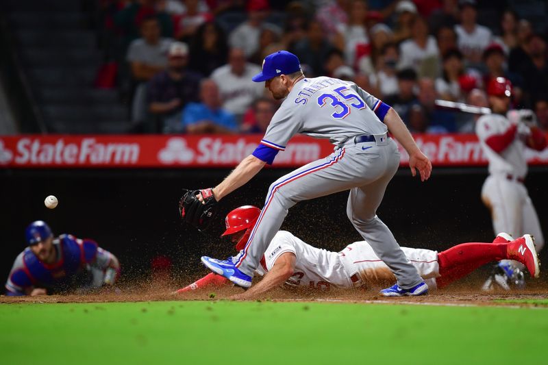 Sep 26, 2023; Anaheim, California, USA; Los Angeles Angels left fielder Randal Grichuk (15) scores a run as Texas Rangers relief pitcher Chris Stratton (35) misses the throw during the fifth inning at Angel Stadium. Mandatory Credit: Gary A. Vasquez-USA TODAY Sports