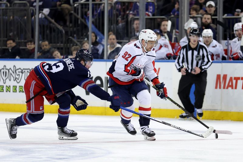 Jan 14, 2024; New York, New York, USA; Washington Capitals center Evgeny Kuznetsov (92) skates with the puck against New York Rangers left wing Alexis Lafreniere (13) during the third period at Madison Square Garden. Mandatory Credit: Brad Penner-USA TODAY Sports