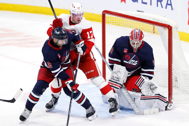 Dec 20, 2023; Winnipeg, Manitoba, CAN; Winnipeg Jets goaltender Laurent Brossoit (39) stops a shot as Detroit Red Wings forward Daniel Sprong (17) is tied up by Winnipeg Jets defenseman Dylan DeMelo (2) in the third period at Canada Life Centre. Mandatory Credit: James Carey Lauder-USA TODAY Sports