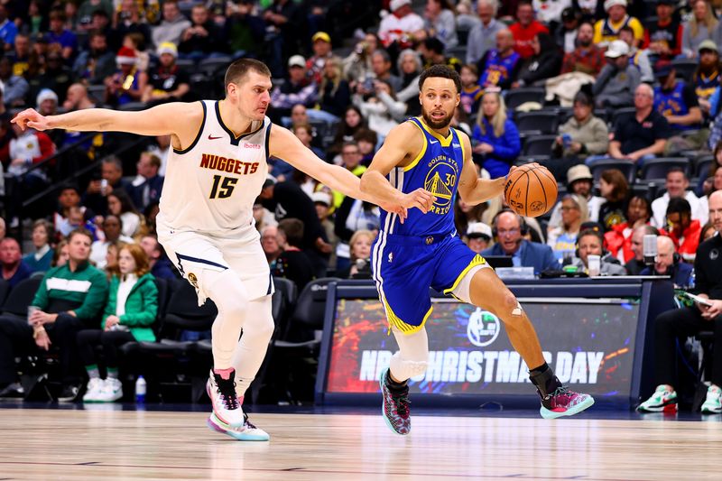 DENVER, COLORADO - DECEMBER 25: Stephen Curry #30 of the Golden State Warriors drives past Nikola Jokic #15 of the Denver Nuggets at Ball Arena on December 25, 2023 in Denver, Colorado. NOTE TO USER: User expressly acknowledges and agrees that, by downloading and/or using this Photograph, user is consenting to the terms and conditions of the Getty Images License Agreement. (Photo by Jamie Schwaberow/Getty Images)