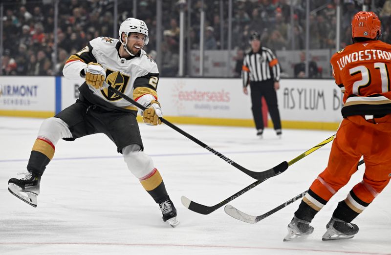 Dec 4, 2024; Anaheim, California, USA;  Vegas Golden Knights defenseman Shea Theodore (27) shoots against Anaheim Ducks center Isac Lundestrom (21) during the third period at Honda Center. Mandatory Credit: Alex Gallardo-Imagn Images