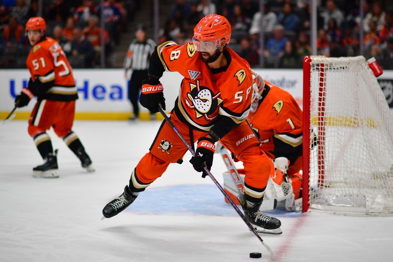 Apr 7, 2025; Anaheim, California, USA; Anaheim Ducks defenseman Oliver Kylington (58) moves the puck against the Edmonton Oilers during the first period at Honda Center. Mandatory Credit: Gary A. Vasquez-Imagn Images