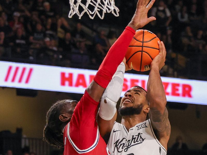 Nov 12, 2024; Orlando, Florida, USA; UCF Knights guard Darius Johnson (3) is fouled by Florida Atlantic Owls guard Ken Evans Jr. (0) during the second half at Addition Financial Arena. Mandatory Credit: Mike Watters-Imagn Images