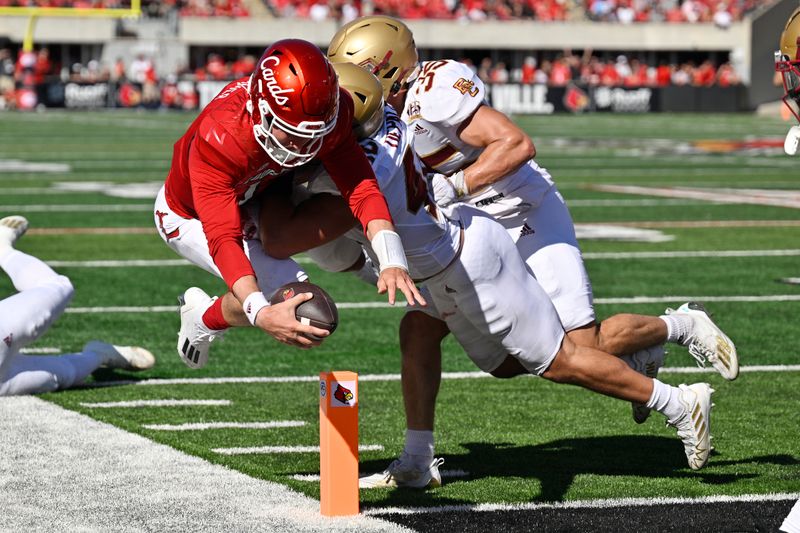 Sep 23, 2023; Louisville, Kentucky, USA; Louisville Cardinals quarterback Jack Plummer (13) lunges for a touchdown against Boston College Eagles linebacker Vinny DePalma (42) during the first half at L&N Federal Credit Union Stadium. Mandatory Credit: Jamie Rhodes-USA TODAY Sports