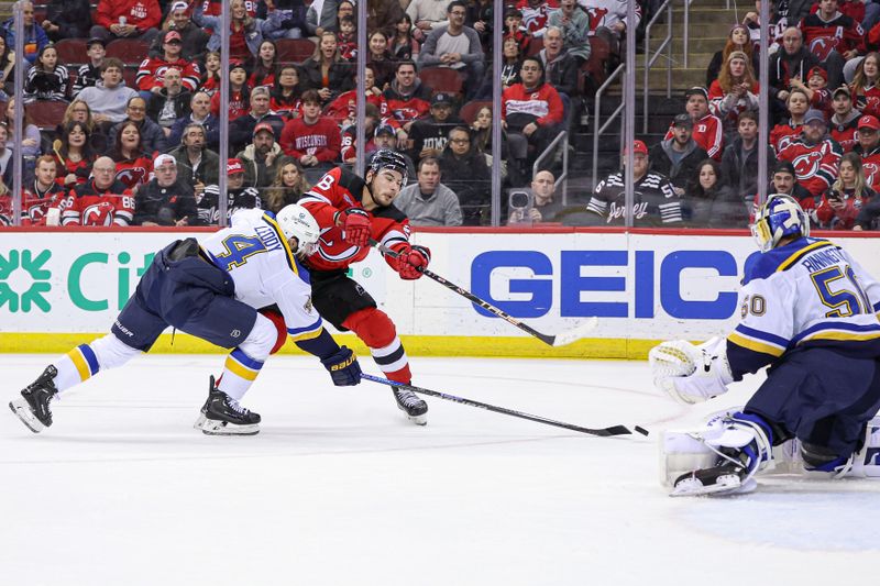 Mar 7, 2024; Newark, New Jersey, USA; New Jersey Devils right wing Timo Meier (28) shoots the puck as St. Louis Blues defenseman Nick Leddy (4) and goaltender Jordan Binnington (50) defend during the first period at Prudential Center. Mandatory Credit: Vincent Carchietta-USA TODAY Sports