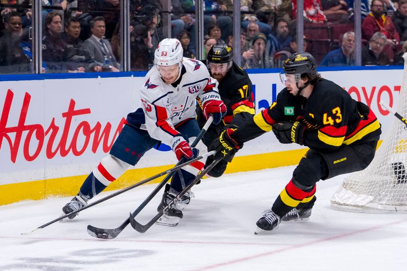 Jan 25, 2025; Vancouver, British Columbia, CAN; Vancouver Canucks defenseman Quinn Hughes (43) and defenseman Filip Hronek (17) stick check Washington Capitals forward Ethen Frank (53) in the third period at Rogers Arena. Mandatory Credit: Bob Frid-Imagn Images