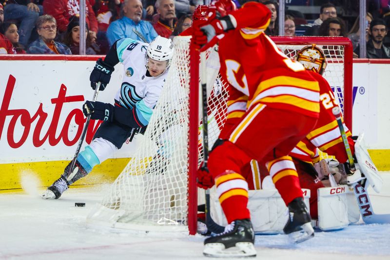 Dec 27, 2023; Calgary, Alberta, CAN; Seattle Kraken left wing Jared McCann (19) controls the puck behind the Calgary Flames net during the first period at Scotiabank Saddledome. Mandatory Credit: Sergei Belski-USA TODAY Sports