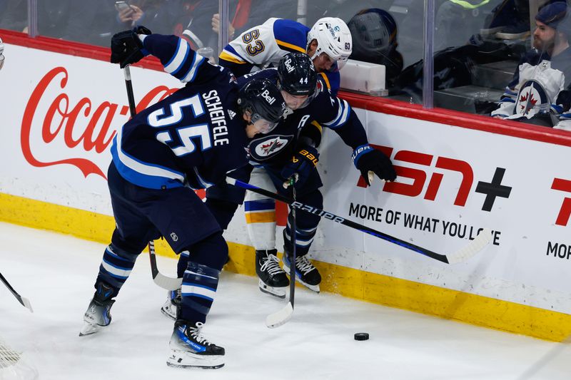 Feb 27, 2024; Winnipeg, Manitoba, CAN; St. Louis Blues forward Jake Neighbours (63), Winnipeg Jets defenseman Josh Morrissey (44) and Winnipeg Jets forward Mark Scheifele (55) battle for the puck during the third period at Canada Life Centre. Mandatory Credit: Terrence Lee-USA TODAY Sports