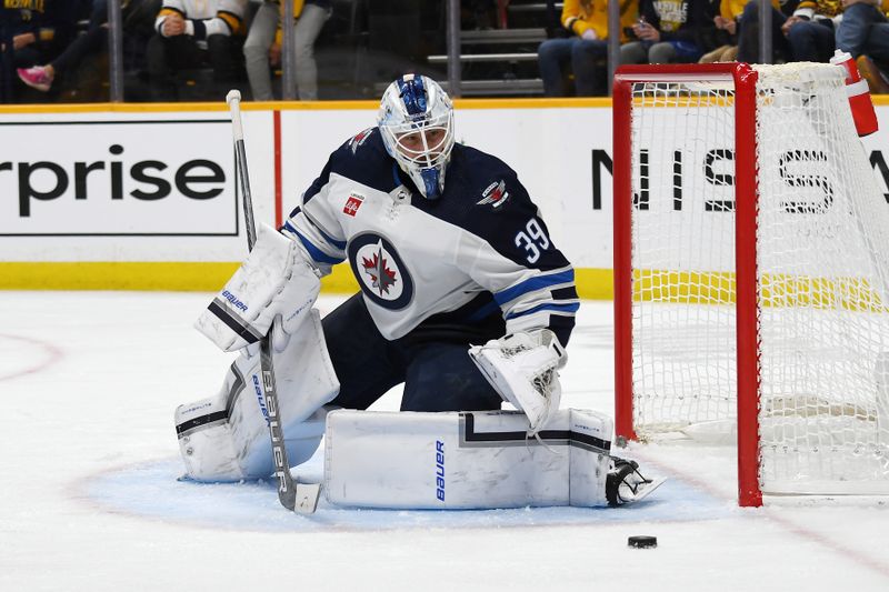 Nov 26, 2023; Nashville, Tennessee, USA; Winnipeg Jets goaltender Laurent Brossoit (39) watches the puck slide into the corner during the first period against the Nashville Predators at Bridgestone Arena. Mandatory Credit: Christopher Hanewinckel-USA TODAY Sports