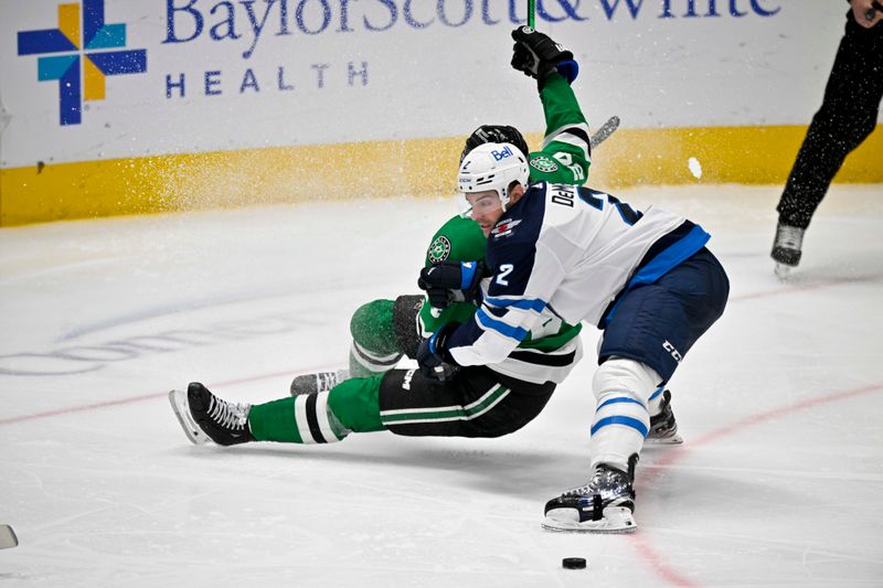 Apr 11, 2024; Dallas, Texas, USA; Winnipeg Jets defenseman Dylan DeMelo (2) takes down Dallas Stars center Roope Hintz (24) during the third period at the American Airlines Center. Mandatory Credit: Jerome Miron-USA TODAY Sports