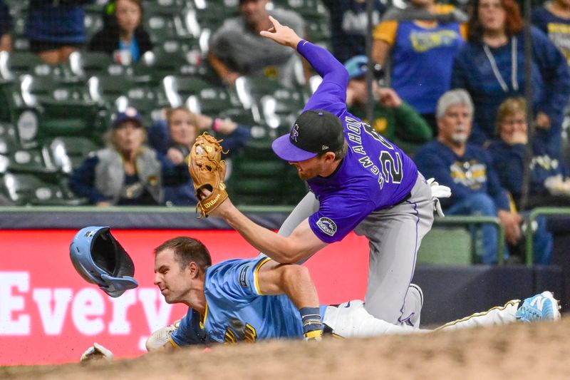 Sep 6, 2024; Milwaukee, Wisconsin, USA; Milwaukee Brewers pinch runner Brewer Hicklen (28) is tagged out by Colorado Rockies third baseman Ryan McMahon (24) trying to advance on a fly ball in the ninth inning at American Family Field. Mandatory Credit: Benny Sieu-Imagn Images