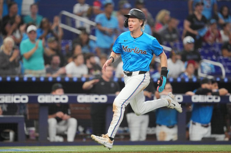 Aug 25, 2024; Miami, Florida, USA;  Miami Marlins left fielder Kyle Stowers (28) scores a run against the Chicago Cubs in the eighth inning at loanDepot Park. Mandatory Credit: Jim Rassol-USA TODAY Sports