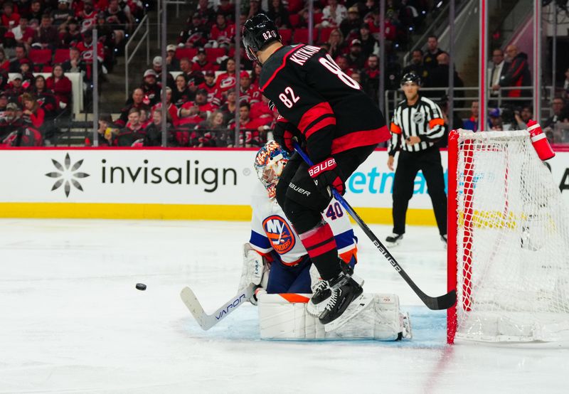 Apr 20, 2024; Raleigh, North Carolina, USA;  Carolina Hurricanes center Jesperi Kotkaniemi (82) and New York Islanders goaltender Semyon Varlamov (40) watch the shot during the third period in game one of the first round of the 2024 Stanley Cup Playoffs at PNC Arena. Mandatory Credit: James Guillory-USA TODAY Sports