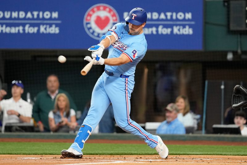 Apr 28, 2024; Arlington, Texas, USA; Texas Rangers first baseman Nathaniel Lowe (30) hits a single against the Cincinnati Reds during the first inning at Globe Life Field. Mandatory Credit: Jim Cowsert-USA TODAY Sports