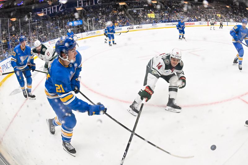Oct 9, 2025; St. Louis, Missouri, USA; St. Louis Blues right wing Jimmy Snuggerud (21) passes the puck past Minnesota Wild center Joel Eriksson Ek (14) during the third period at Enterprise Center. Mandatory Credit: Jeff Curry-Imagn Images