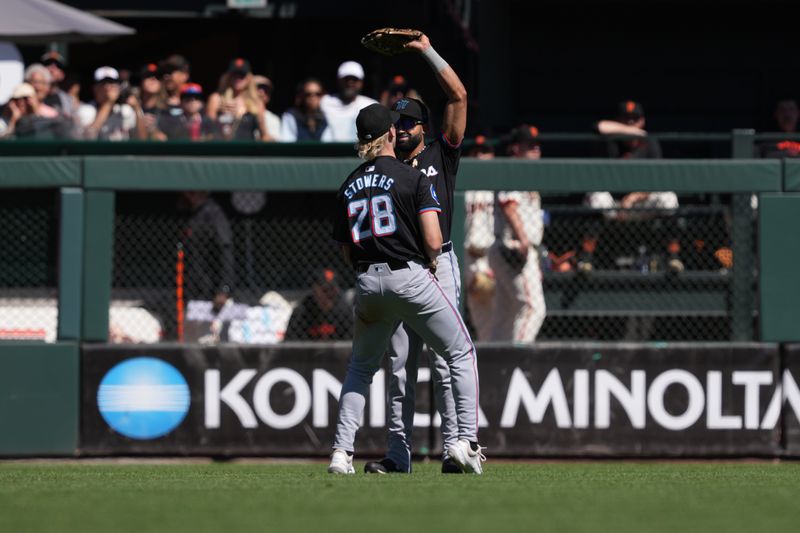 Sep 1, 2024; San Francisco, California, USA; Miami Marlins center fielder Derek Hill (right) reacts after catching a fly ball with left fielder Kyle Stowers (28) during the seventh inning at Oracle Park. Mandatory Credit: Darren Yamashita-USA TODAY Sports