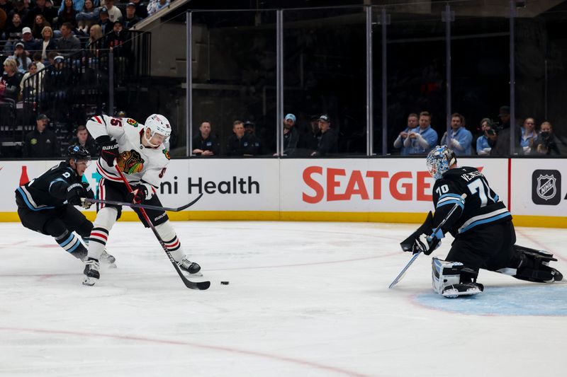 Feb 25, 2025; Salt Lake City, Utah, USA; Chicago Blackhawks right wing Ilya Mikheyev (95) prepares to shoot as Utah Hockey Club defenseman Olli Maatta (2) defends and goaltender Karel Vejmelka (70) tends the net during the second period at Delta Center. Mandatory Credit: Rob Gray-Imagn Images