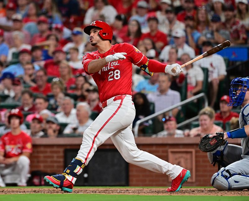 Aug 17, 2024; St. Louis, Missouri, USA;  St. Louis Cardinals third base Nolan Arenado (28) hits a solo home run against the Los Angeles Dodgers in the eighth inning at Busch Stadium.  At right is Los Angeles Dodgers catcher Will Smith. Mandatory Credit: Tim Vizer-USA TODAY Sports