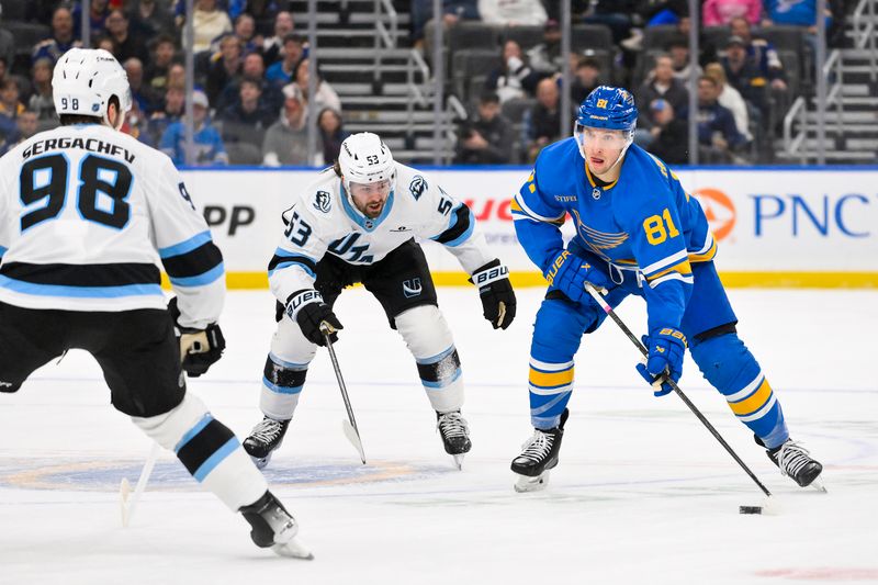 Oct 23, 2025; St. Louis, Missouri, USA; St. Louis Blues left wing Dylan Holloway (81) controls the puck as Utah Mammoth left wing Michael Carcone (53) and defenseman Mikhail Sergachev (98) defend during the second period at Enterprise Center. Mandatory Credit: Jeff Curry-Imagn Images